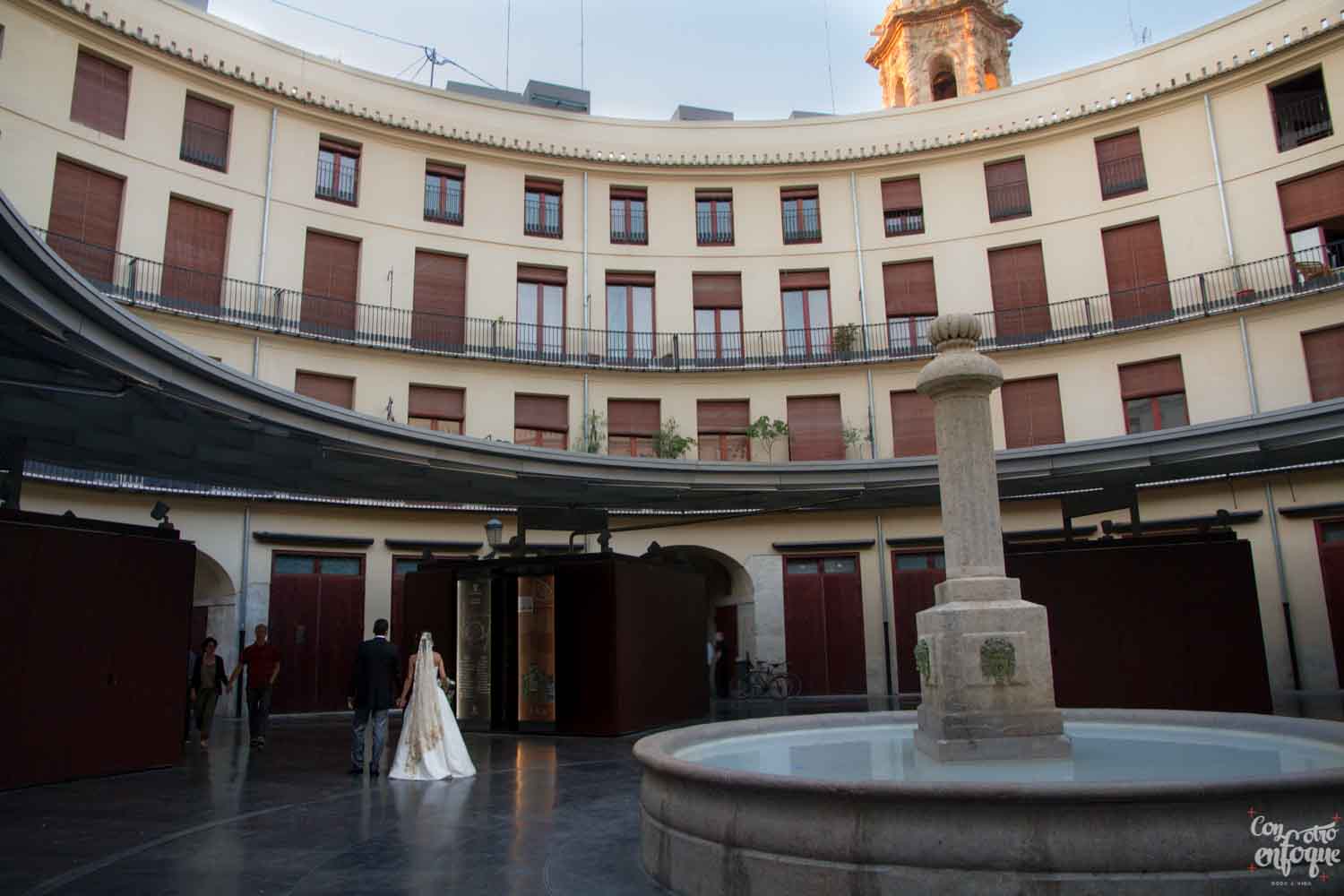 novios por la plaza redonda de Valencia. Boda en ciudad histórica. Fotógrafos de boda