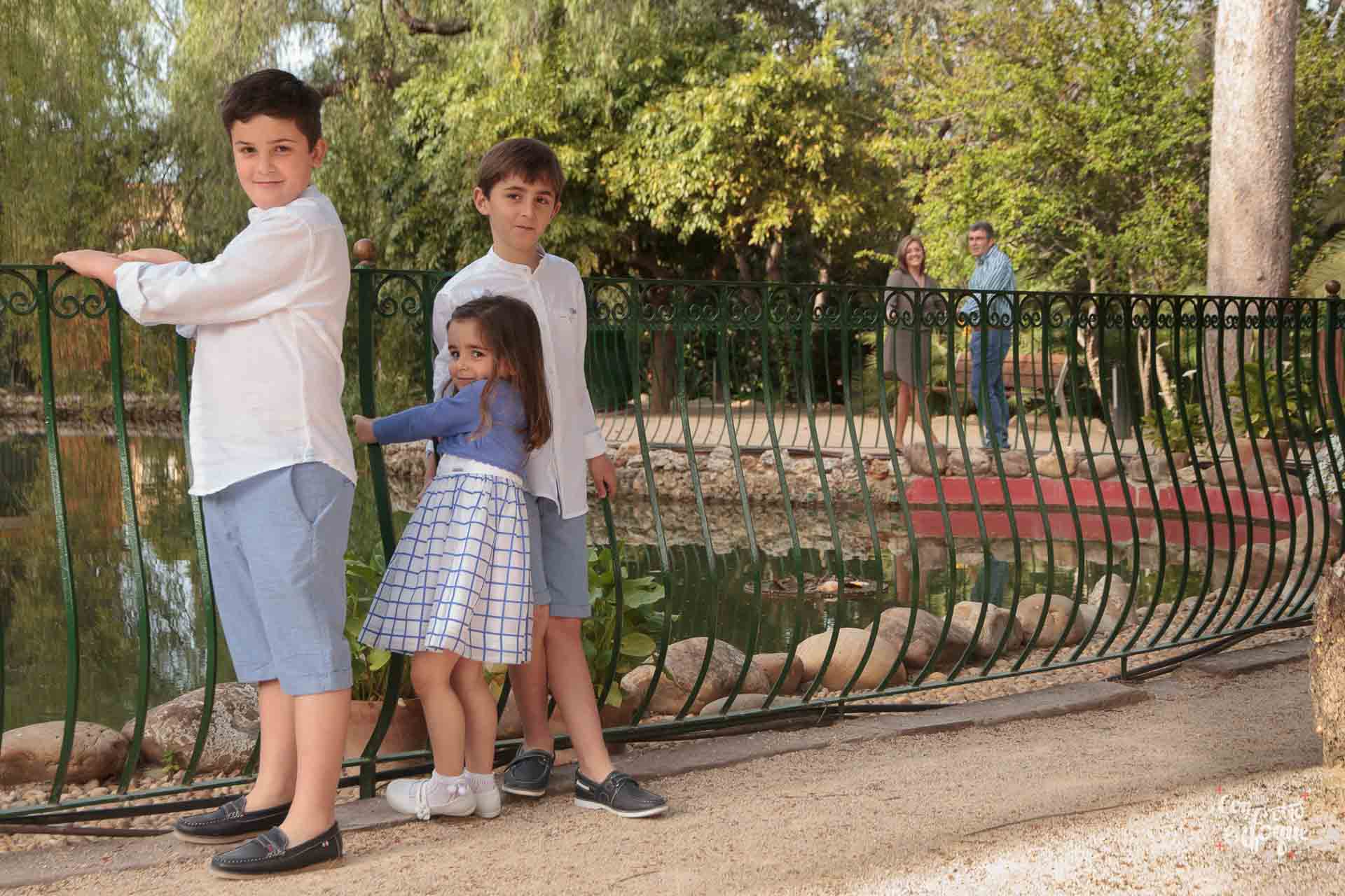 niño de comunión con sus hermanos en parque de Valencia